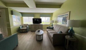 A living room with a television, sofa, armchair, coffee table, and lamps. - Cozy Queen Bedroom in Delray Beach Near Beach & Downtown (Delray Beach)