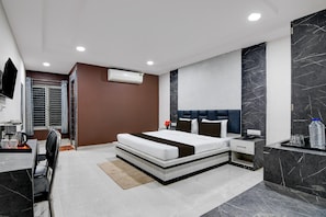 Een moderne hotelkamer met een groot bed, een nachtkastje, een ingebouwde televisie en een badkamer met douche en toilet.