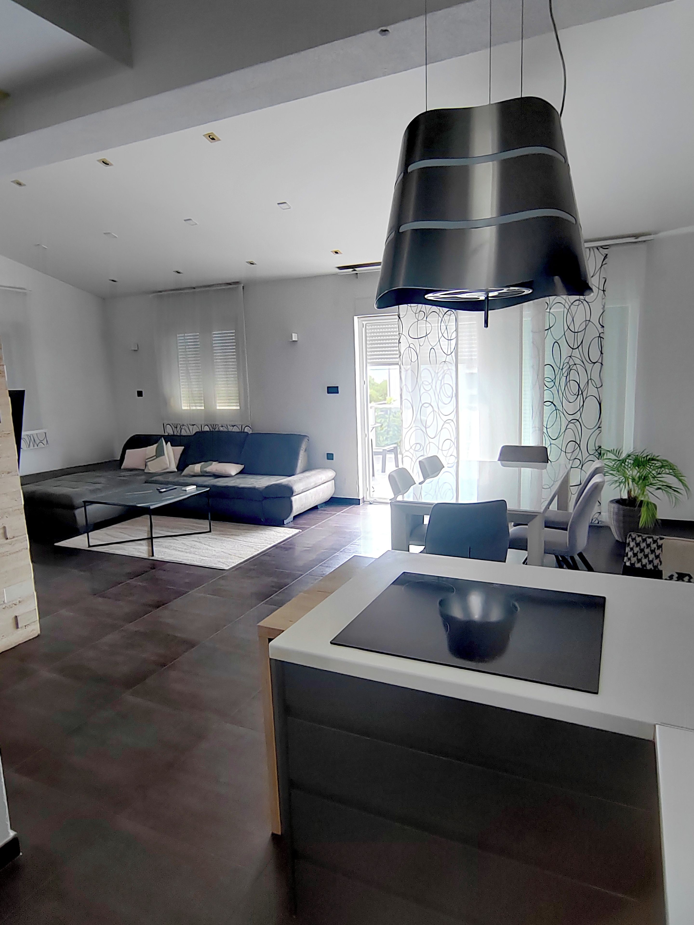A modern living room with a sofa, a coffee table, and a dining area with chairs.