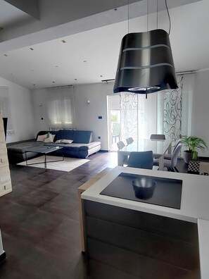 A modern living room with a sofa, a coffee table, and a dining area with chairs. - New luxurious apartment loreta (Zadar)
