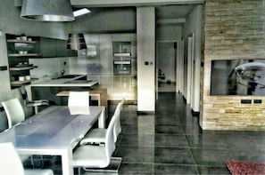 A modern kitchen with a dining area, a fireplace, and a view into the living room. - New luxurious apartment loreta (Zadar)