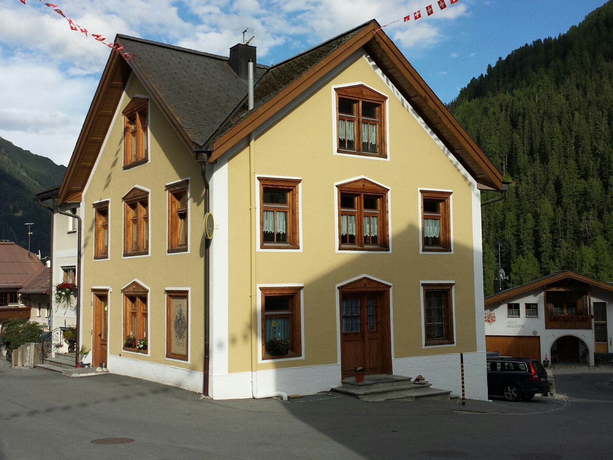 Un bâtiment à deux étages, doté de nombreuses fenêtres et d’un toit en pente, situé dans une région montagneuse.