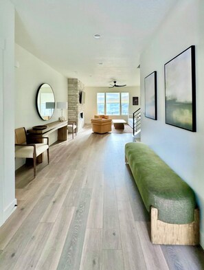 A spacious interior with a long hallway, a seating area with a bench, and a fireplace. - Awesome 5-bedroom townhome near Deer Valley (Heber City)