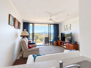 A hotel room with a balcony, a sofa, a television, and a ceiling fan. - Gold Coast central, fabulous golf course resort, near beach, shops, restaurants (Clear Island Waters)