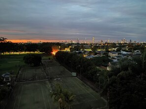 A cityscape at dusk with a park and sports field in the foreground. - Gold Coast central, fabulous golf course resort, near beach, shops, restaurants (Clear Island Waters)