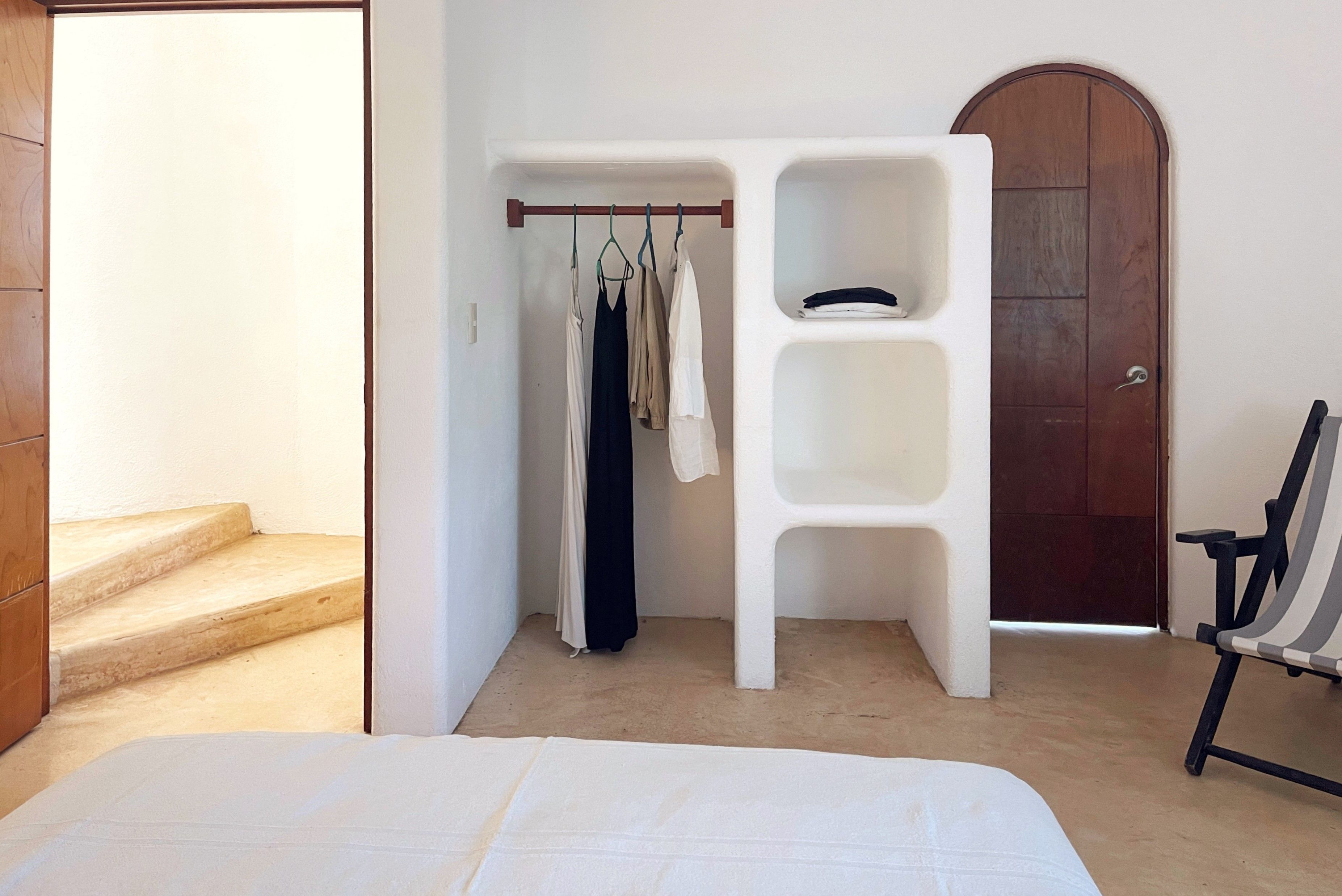 Ein Schlafzimmer mit einem Bett, einem Kleiderschrank und einem Sessel.