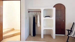 Quarto com cama, guarda-roupa e uma cadeira.