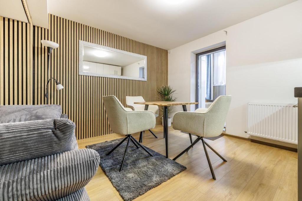 Una sala de estar moderna con un sofá, una mesa de comedor con sillas, un espejo y un radiador.