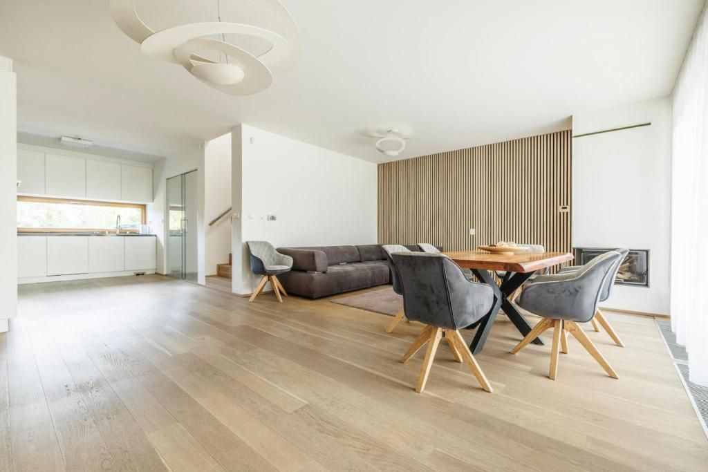 En moderne stue med spiseplads, sofa og køkken i baggrunden.