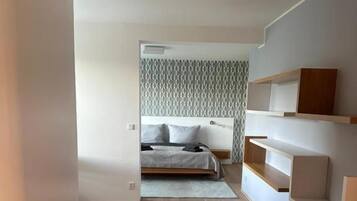 Une chambre à coucher moderne avec un lit, des tables de chevet et une armoire.
