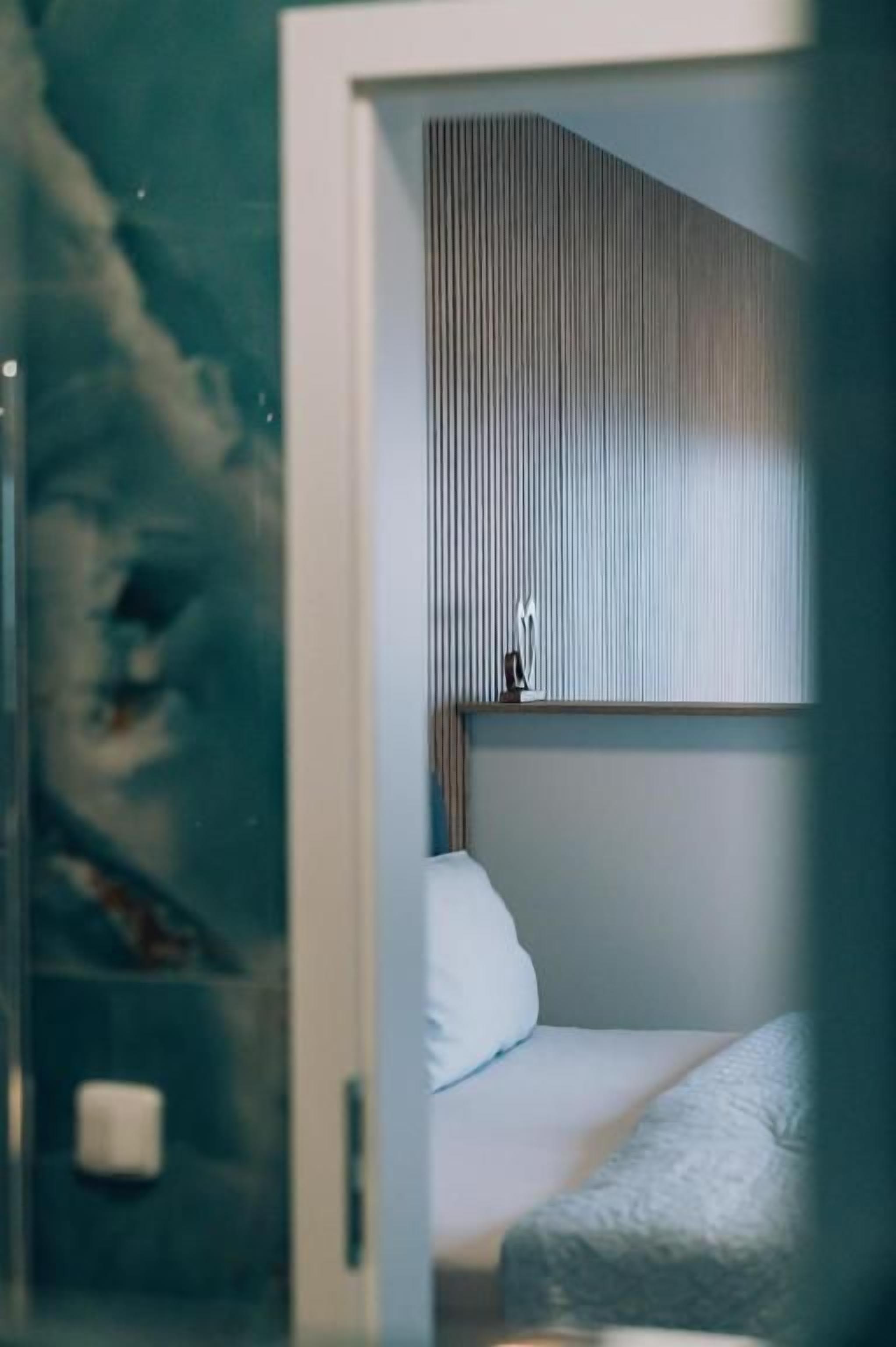Una habitación con una cama, una mesita de noche y una ventana con persianas.