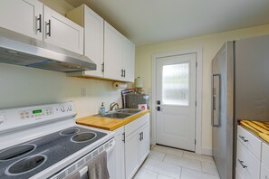 A compact kitchen with white cabinets, a stainless steel range, a built-in oven, a sink, and a refrigerator. - 2 Mi to Dtwn Savannah! WFH-Friendly Retreat (Savannah)