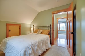 Een slaapkamer met een bed, een houten deur en uitzicht op een balkon.