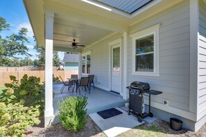 A covered patio with a ceiling fan, a barbecue grill, and a dining table with chairs. - Brand-New Cottage Minutes to Lake Marion & Golf (Summerton)