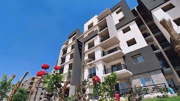 A multi-story residential building with balconies and a clear sky.