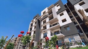 Un immeuble résidentiel à plusieurs étages, doté de balcons, avec un ciel dégagé.