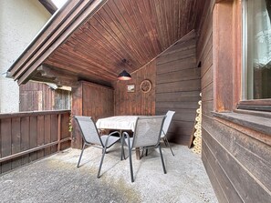 An outdoor patio with a table and chairs, wooden walls, and a window. - Ferienhaus Christl by Interhome (Pians)