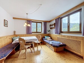 A cozy room with a wooden table, chairs, a bench, and a bed with a headboard. - Ferienhaus Christl by Interhome (Pians)