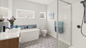 Een moderne badkamer met douche, toilet en wastafel.