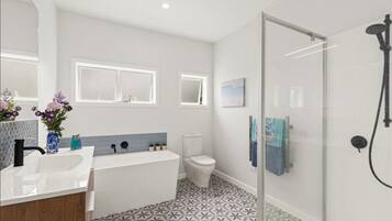 A modern bathroom with a shower, toilet, and sink.