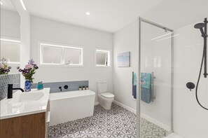 A modern bathroom with a shower, toilet, and sink. - Villa Vie: Spacious family escape in Warkworth near Matakana (Warkworth)