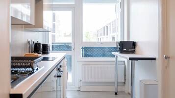 A modern kitchen with a built-in oven, a coffee machine, and a microwave on a countertop.