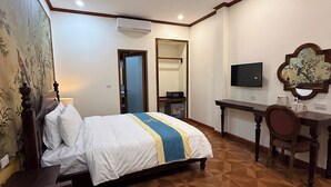 A hotel room with a bed, a desk, a chair, a television, and a mirror. - La Armber Hotel (Luang Prabang)