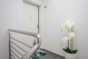 Eine Treppe mit Metallgeländer, das zu einer weißen Tür führt.