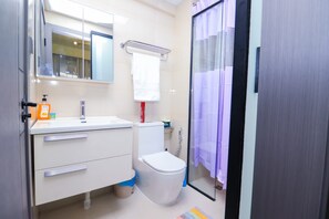 Un baño moderno con inodoro, lavabo y ducha.