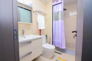 Ein Badezimmer mit Toilette, Waschbecken und Duschbereich.