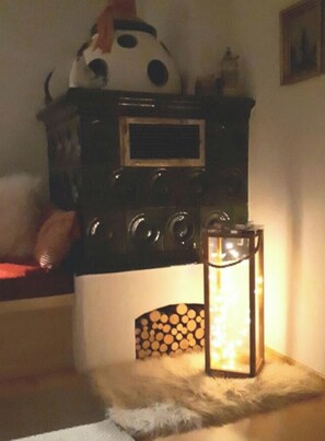 Ein Zimmer mit Kamin, einer dekorativen Laterne und einer an der Wand befestigten Uhr.