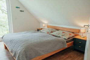 A bedroom with a bed, nightstands, and a window. - Lakefront property, bathing bay (Krakow am See)