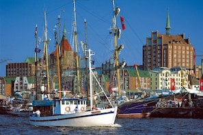 Ein Hafen mit Booten, einer markanten Kirche und einer Mischung aus Wohn- und Geschäftshäusern.