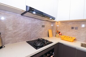 Eine moderne Küche mit einem Gasherd, einem Backofen und einer schwarzen Dunstabzugshaube.