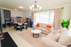 Ein modernes Wohnzimmer mit Sofa, Couchtisch und Essbereich.