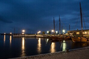 A marina at night with boats docked and lights reflecting on the water. - Holiday home with 2 bedrooms (Fuhlendorf)