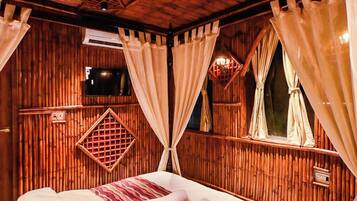 A room with a bed, curtains, a ceiling fan, and a window with a view.