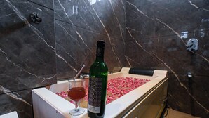 A bottle of Samara wine and a glass with a drink on a marble countertop. - Inder Fateh Niwas  (Jodhpur)