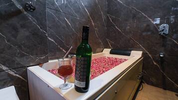 Une bouteille de vin de Samara et un verre contenant une boisson, posés sur un comptoir en marbre.