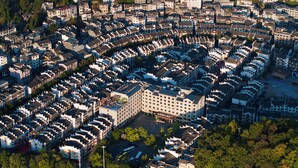 Una zona residencial densa amb arquitectura tradicional, incloent edificis de diversos pisos amb teulades a vessant i parets blanques.