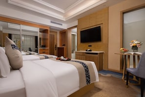 Ein Hotelzimmer mit Bett, Schreibtisch, Stuhl, Fernseher und Spiegel.