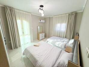 Ein Hotelzimmer mit zwei Betten, einem Nachttisch, einem Spiegel und einer Deckenleuchte.