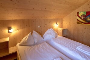 A wooden room with a bed, two bedside tables, and wall-mounted lights. - Chalet #12b with IR sauna & whirlpool (St. Georgen am Kreischberg)