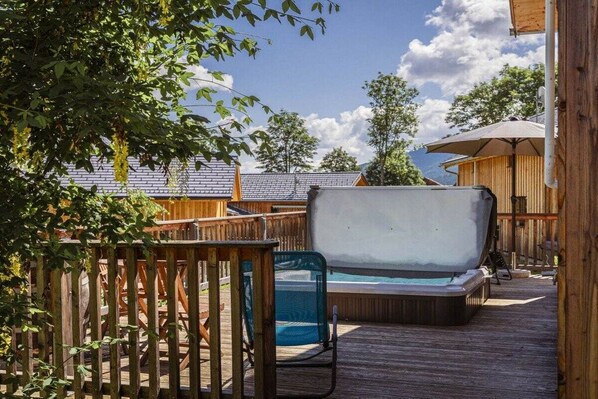 A wooden deck with a hot tub, a pool, and a covered seating area. - Cabin with 1 bedroom (St. Georgen am Kreischberg)