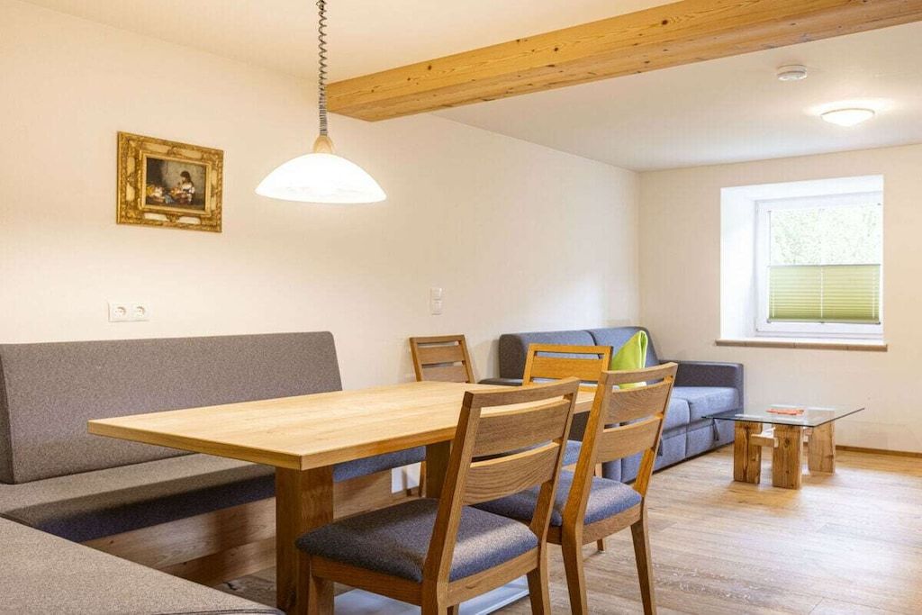 Un coin repas avec une table et des chaises en bois, un canapé gris et une petite table basse.
