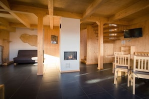 A wooden interior with a fireplace, a sofa, and a TV mounted on the wall. - Cabin in Turrach with sauna and terrace (Turrach)