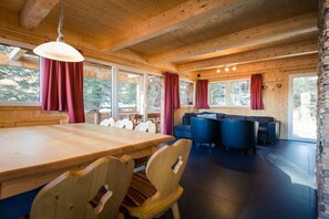 A wooden interior with a dining table, chairs, and a sofa area. - Cabin in Turrach with sauna and balcony (Turrach)