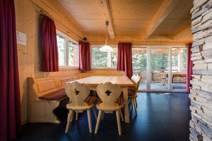 A wooden interior with a bench seating area, a table, and chairs. - Cabin in Turrach with sauna and balcony (Turrach)
