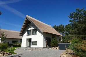 A modern two-story house with a sloped roof, a paved driveway, and a small garden area. - Str. d. Freundschaft 30c (Karlshagen)