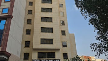 A tall hotel building with multiple floors and a sign indicating it is the Rowad Al Mashaer Al Rawdah Hotel.